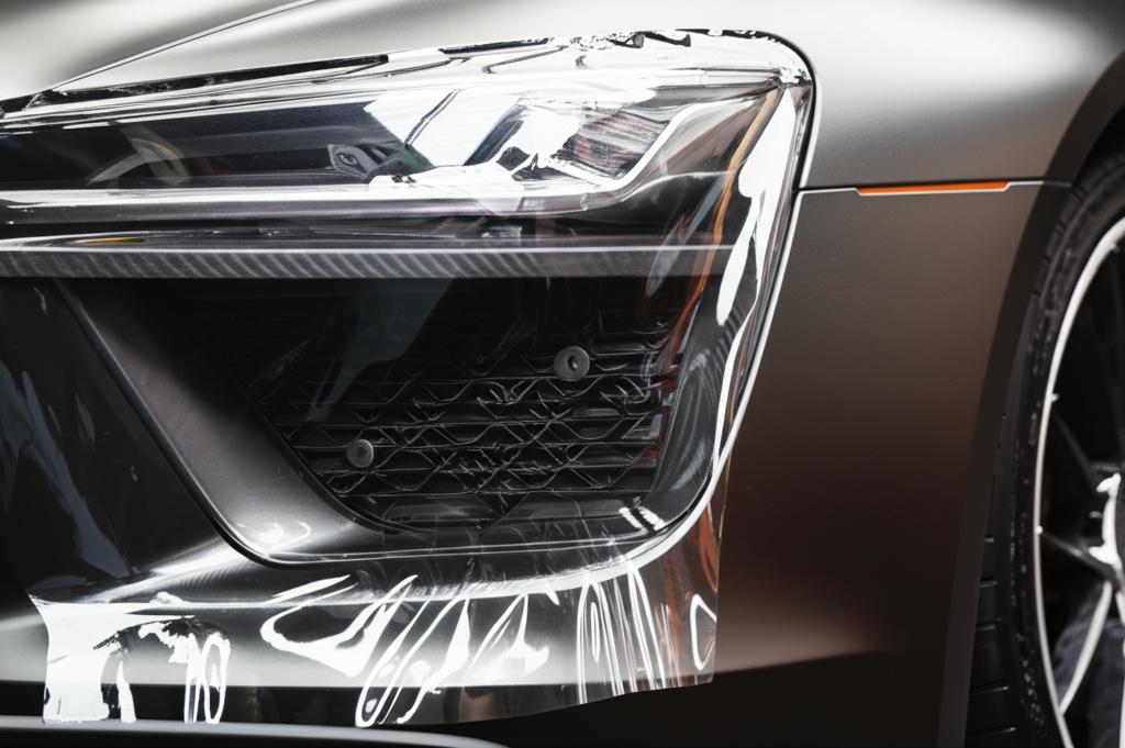 Close-up view of TPU film being expertly installed on a luxury car panel