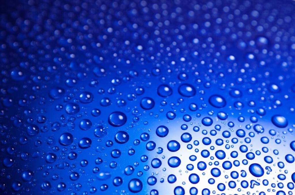 Close-up of car paint with water beading on TPU film